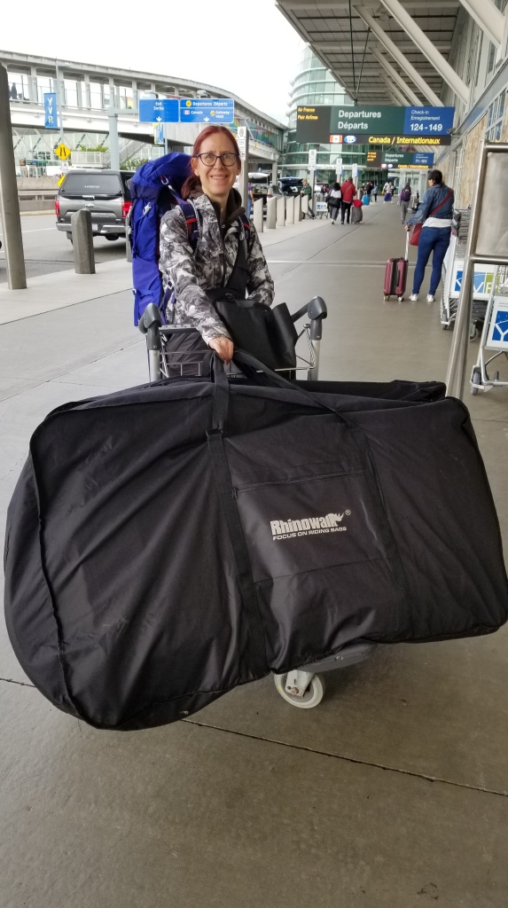 At the airport, showing a bike packed in the bike bag on a luggage cart